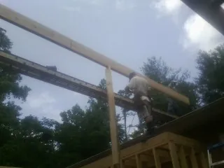 Carpenter setting a ridge beam over a new addition frame — Ice Dam Removal by Roofing Brothers in Granada Hills