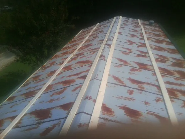 Rusted metal roof panels with new wood purlins before replacement — Storm Damage Roof Repair in Granada Hills by Roofing Brothers