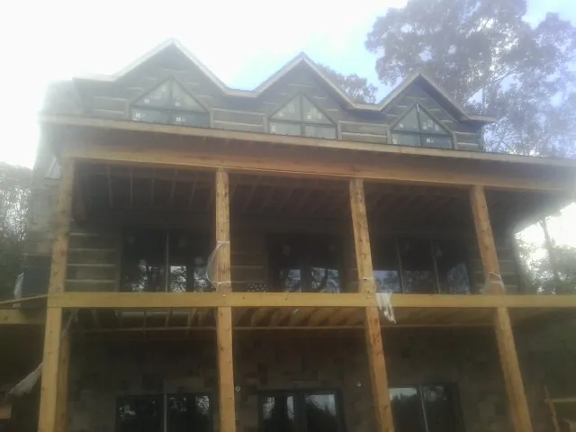 Dormers and porch framing on a large log home under construction — Roof Coating work by our crew in Granada Hills