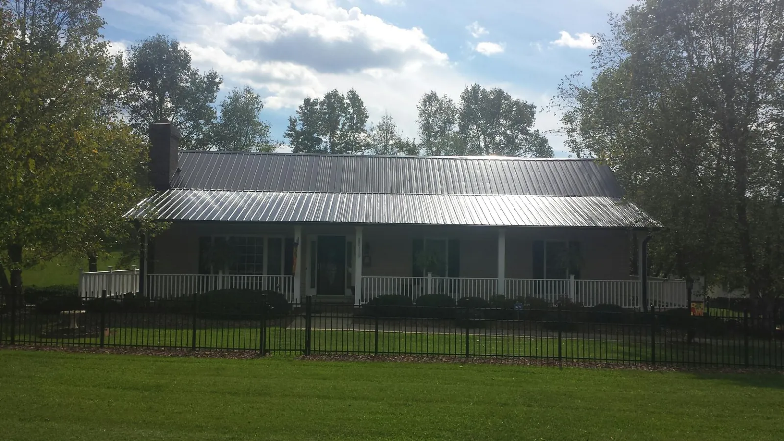 Gray metal roof on a brick ranch with a full width front porch — Gutter Guard Installation work by our crew in Granada Hills