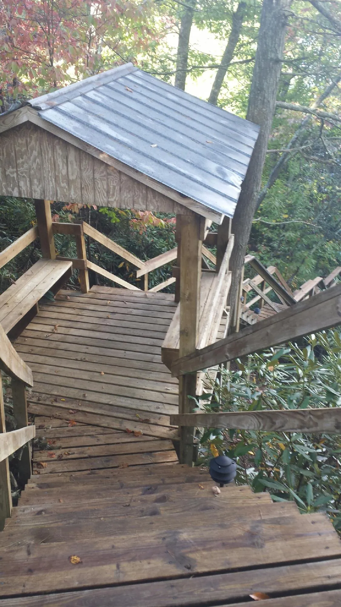 Metal roofed shelter over wooden steps on a wooded walkway — Skylight Repair & Installation work by our crew in Granada Hills