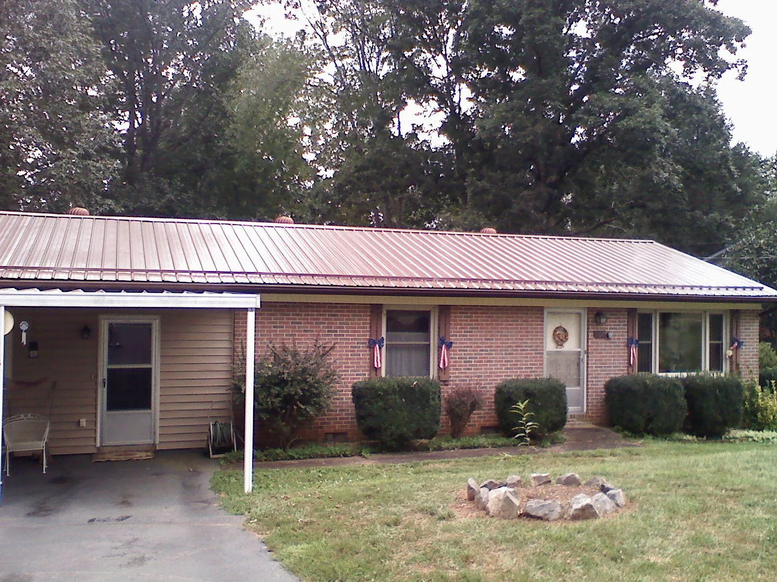 Bronze metal roof and carport on a brick ranch home — Roof Repair work by our crew in Granada Hills